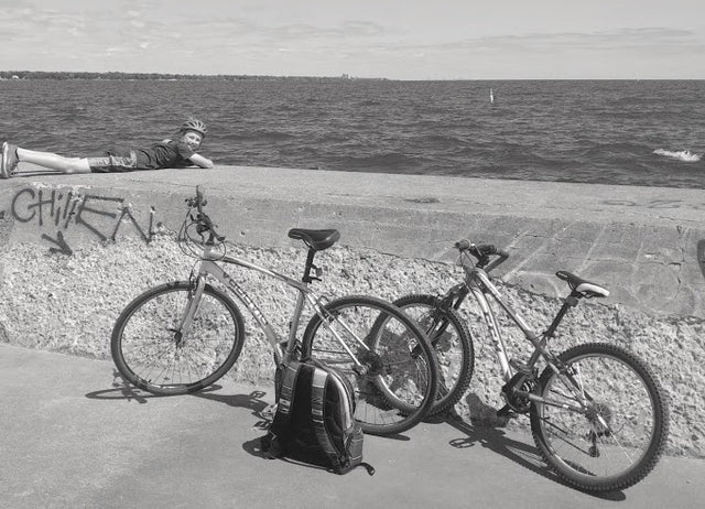 Boy on Breakwater with bikes in foreground on harbour front